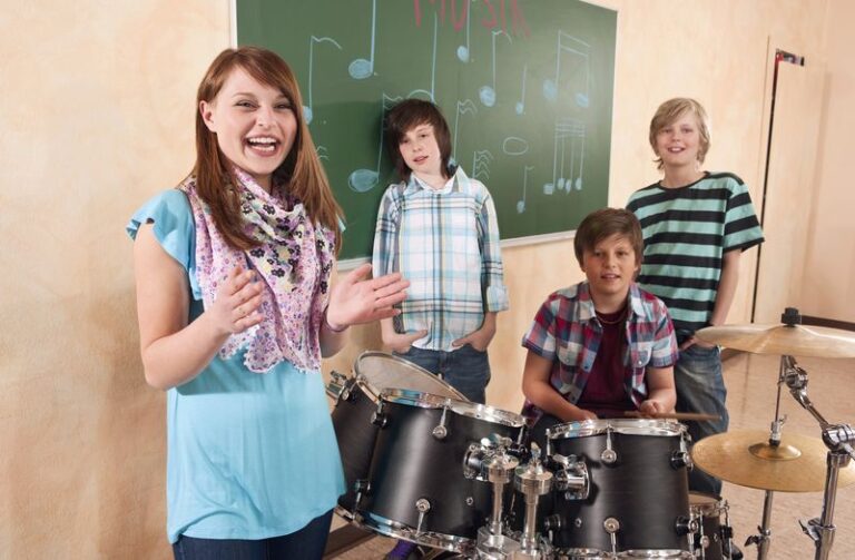 Germany, Emmering, Girl smiling with boys in background playing drum, portrait