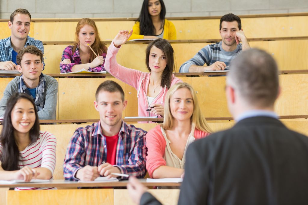 Rear view of an elegant teacher with students sitting at the college lecture hall